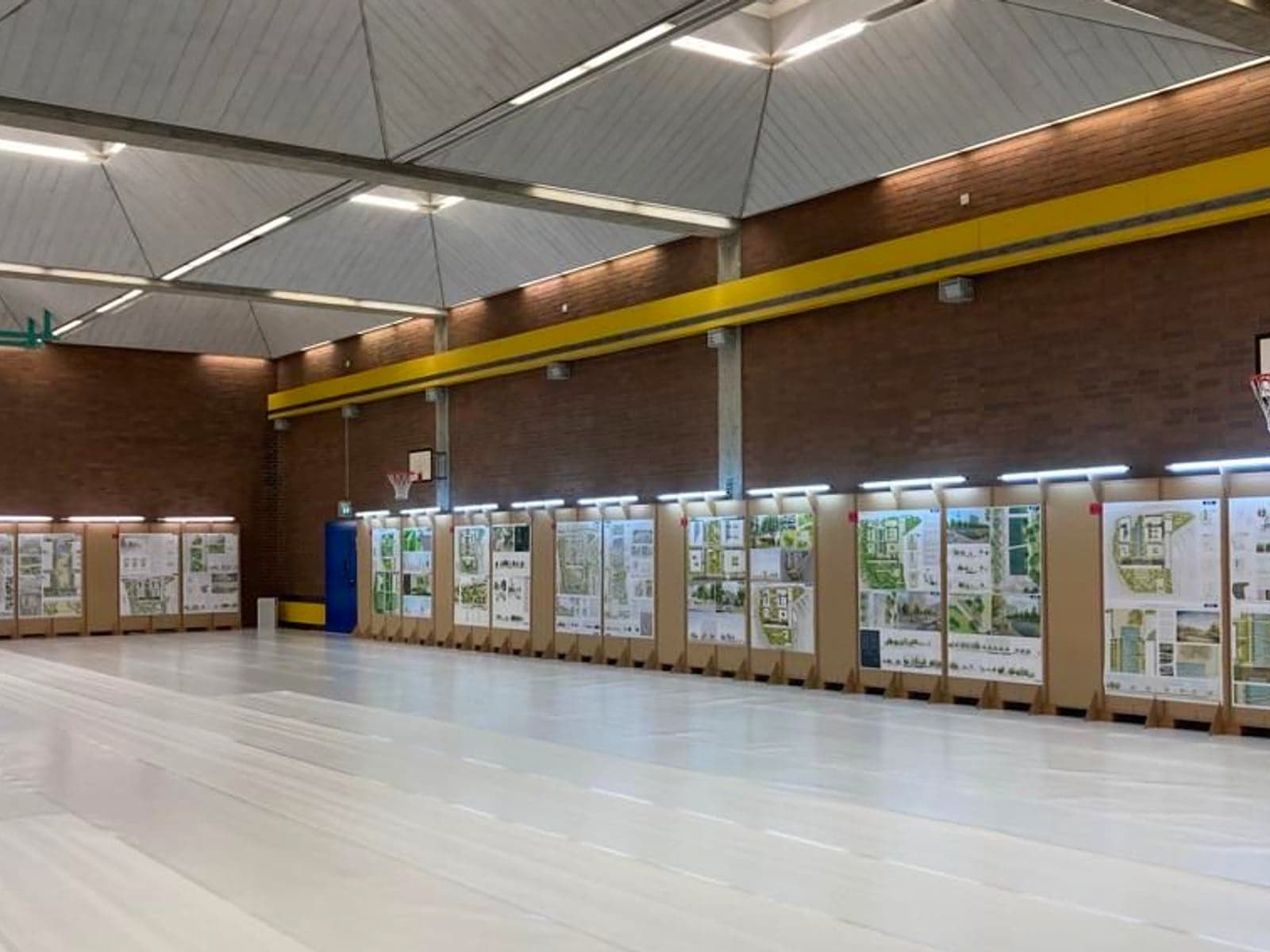Turnhalle mit ausgelegtem Boden und beleuchteten Stellwänden