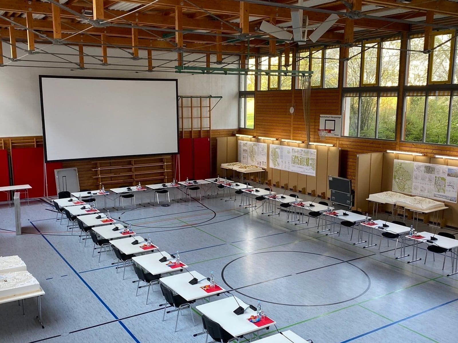 Preisgerichtssitzung mit Leinwand in Turnhalle